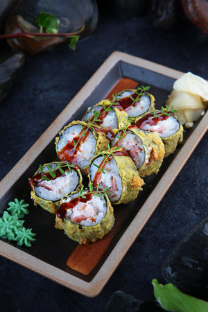Rolls in tempura. Traditional Japanese cuisine. Ebi tempura. White ginger. Vertical photo on a black background with smoke.View from above.の写真素材