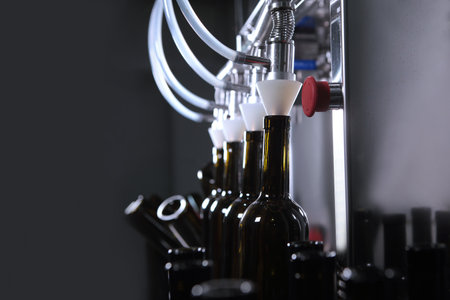 Bottled wine. Young wine is poured into bottles. A small winery.Selective focus.の写真素材