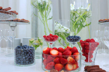 Berries in the assortment on the table. Light snacks on a festive day.Strawberries, raspberries and blueberries on the festive table.の写真素材