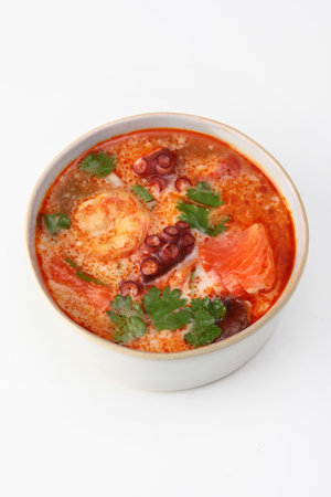Soup with seafood and tomatoes. Soup with octopus, king prawns and red fish.Vertical photo.Isolated object. White background.の写真素材