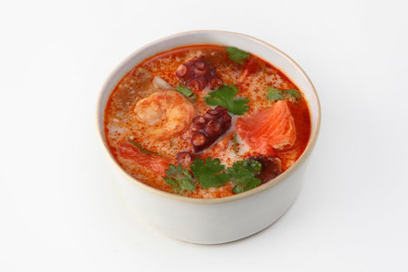 Soup with seafood and tomatoes. Soup with octopus, king prawns and red fish. Isolated object.White background.の写真素材