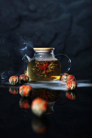 Chinese tea with jasmine. Jasmine tea in a transparent teapot. Opening of the flower. A healthy drink.Dried flower.Elite grade of tea.Vertical photo.の写真素材
