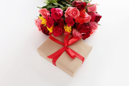 Red bouquet of roses, a gift box with a bright ribbon on a white background with a place for text. The concept of a Valentines Day greeting card, March 8, happy birthday.Copy space.Flat lay.Top view.の写真素材