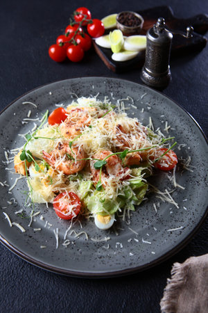 Caesar salad with shrimp.On a dark background. Without people. Vertical photo.の写真素材