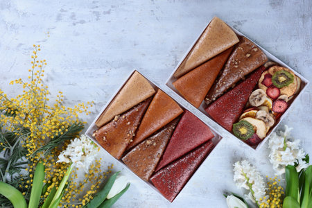 Fruit pastille. The pastille is rolled up in the form of a cone. Vegan sweets, dessert without sugar. Spring flowers. The concept of healthy eating.の写真素材