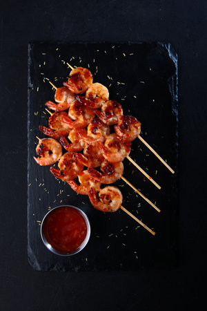 Shrimp fried on skewers. Appetizer for beer. On a stone background. Flat lay.Top view.の写真素材