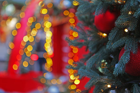 Christmas garlands and fir branches. The branches of the spruce are decorated with balls. Christmas texture for postcards. Garland with lights on the Christmas tree.の写真素材