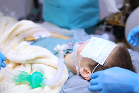 Little boy is under general anesthesia. Dental treatment under anesthesia. Breathing tube in the babys mouth. Surgical intervention.の写真素材