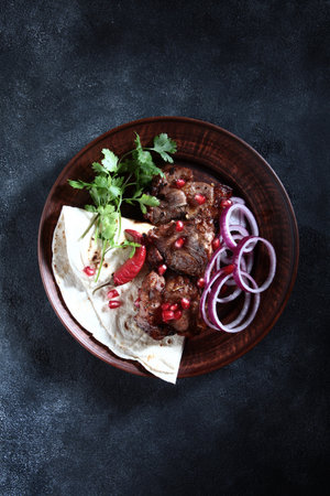 Grilled meat. Hot red pepper on a plate. Cut the red onion into rings. Pomegranate seeds along with meat. Top view, leave room for copying.の写真素材
