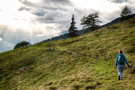Lonely girl walking to the sunset in Austria mountains (Tyrol)の写真素材