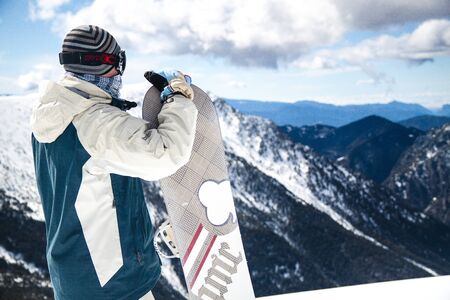 Man standing with snowboard in Andorra mountainsの写真素材