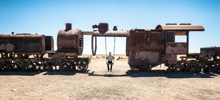 Man on a swing in Uyuni train cemeteryの写真素材