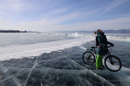 Girl with a bicycle in iced Baikal lakeの写真素材