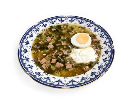 Okroshka with sour cream and sliced half an egg in a porcelain dish on a white background (side view)の写真素材