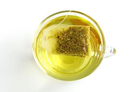 The bag of green herbal tea in a glass bowl with water, isolated on a white backgroundの写真素材