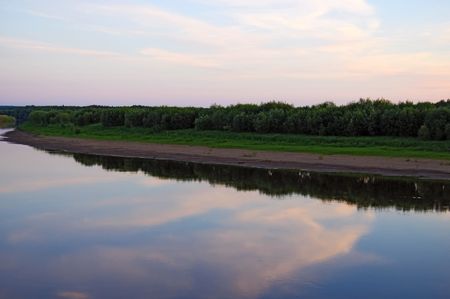 A beautiful sunset on the river Sosva in the Northern Urals, clouds, painted in red, orange, forest,...