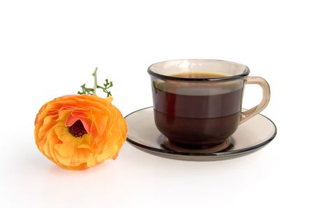 Cup and saucer made of brown glass with hot coffee and orange flower isolated on white backgroundの写真素材