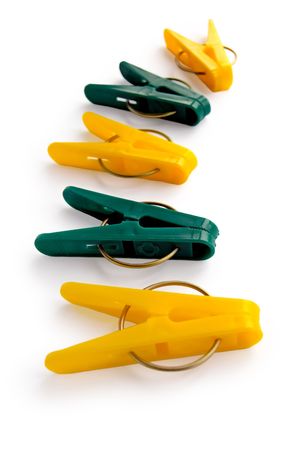 A number of yellow and green clothespins isolated on a white backgroundの写真素材