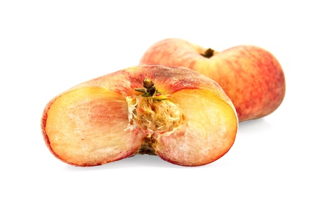 One whole and half red-yellow flat peaches isolated on white backgroundの写真素材