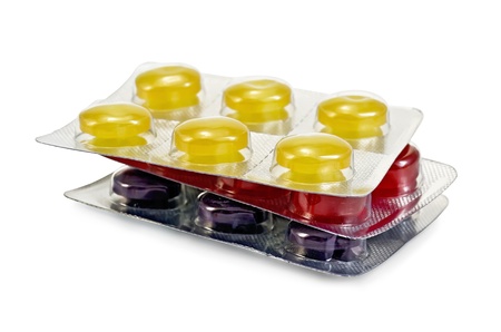 A stack of three packages of cough pills in different colors isolated on white background