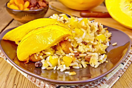 Pilaf fruit with pumpkin in brown plate on boardの写真素材