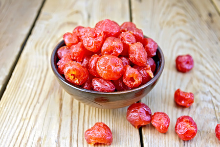 Candied cherries in bowl on boardの写真素材