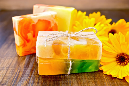 Homemade soap, yellow marigold on a wooden boards backgroundの写真素材