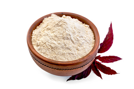 Amaranth flour in a clay bowl and purple amaranth flower isolated on white backgroundの写真素材