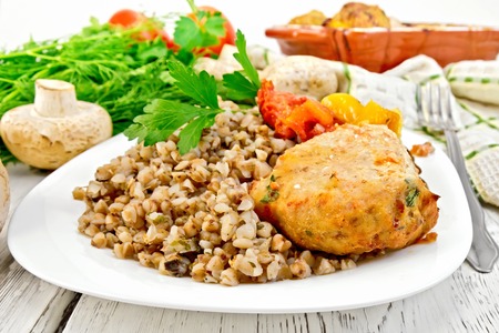 Cutlet of turkey meat with buckwheat, mushrooms, tomatoes and peppers in the dish.の写真素材