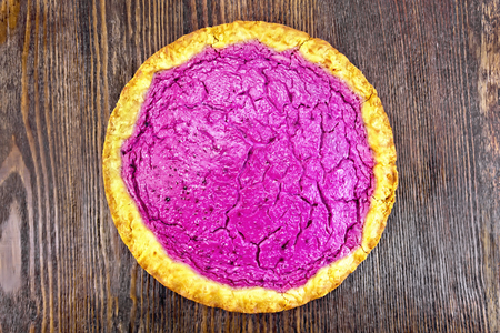 Piece of sweet cake with blackcurrants, blueberries or blackberries with cream on a background of wooden boards topの写真素材