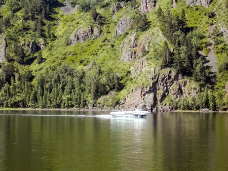 boat floating on the river along the mountains and forests. Passenger boat.の写真素材