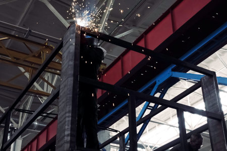 A welder in a mask welds the channel. Welding