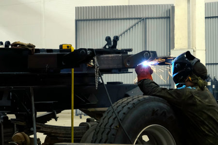 A welder in a mask welds the channel. Welding