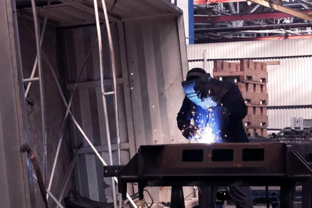 A welder in a mask welds the channel. Welding