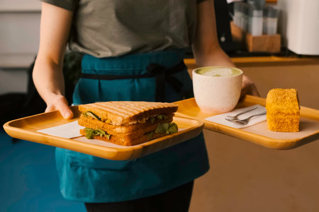 A mug of coffee with a piece of cake on a tray. Morning breakfast at the cafe.の写真素材