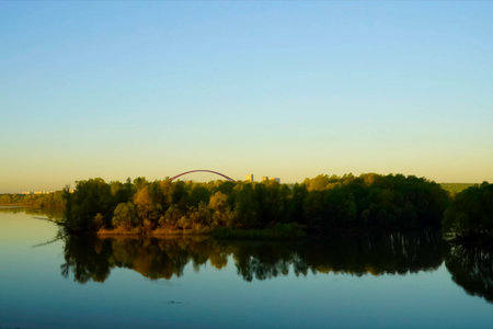 Autumn river landscape, view of water, trees and bridge outside the city.