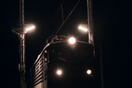 The leading locomotive of the train in the night. A traveling train.