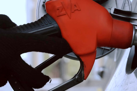 A petrol pistol is inserted into the neck of the car's gas tank.の写真素材