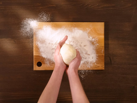Rolling out the dough in flour on a wooden board.