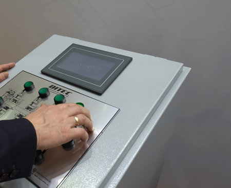 Control panel for asynchronous motors. Operator at work at the control panel.