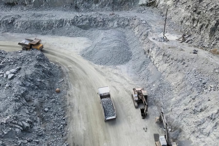 Trucks carry migmatite and crushed stone in the quarry