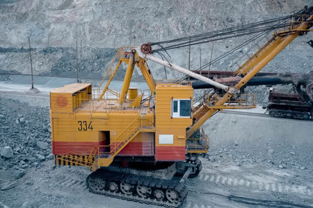 Loading of crushed stone into trolleys using an excavator.