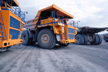 Mining dump trucks are parked in a row. Equipment for an quarry.