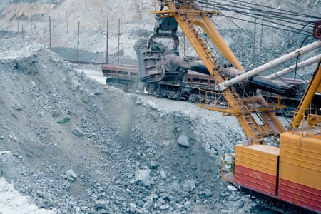 Loading of crushed stone into trolleys using an excavator.