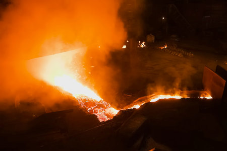 A stream of molten steel flowing from a blast furnace.