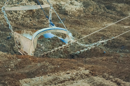 A dragliner bucket on cables scoops up soil at a gold mineの写真素材