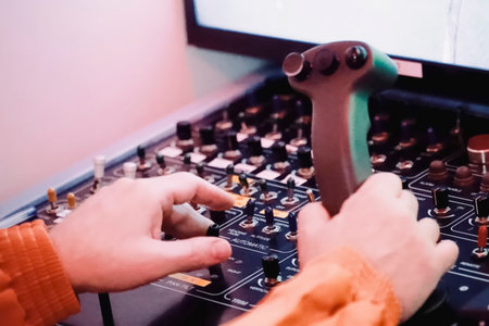 the hands of the operator controlling the robot manipulator on the robot control panel and on the movement joystick.の写真素材