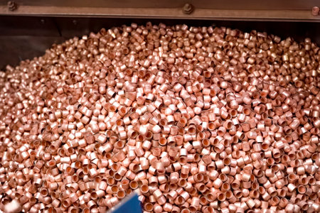 Blank cylinders for cartridge case manufacturing, ammunition production conveyor.