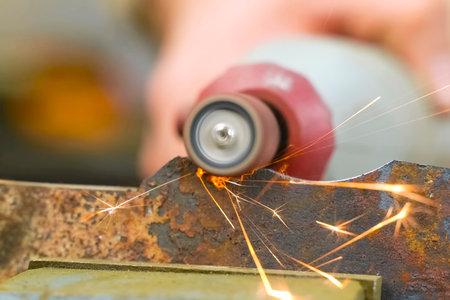 Grinding small parts on a knife using a rotary tool with a grinding head.の写真素材