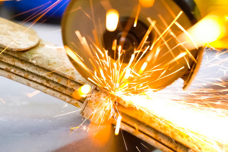 Cutting steel with angle grinder, sparks from sawing car leaf springs.